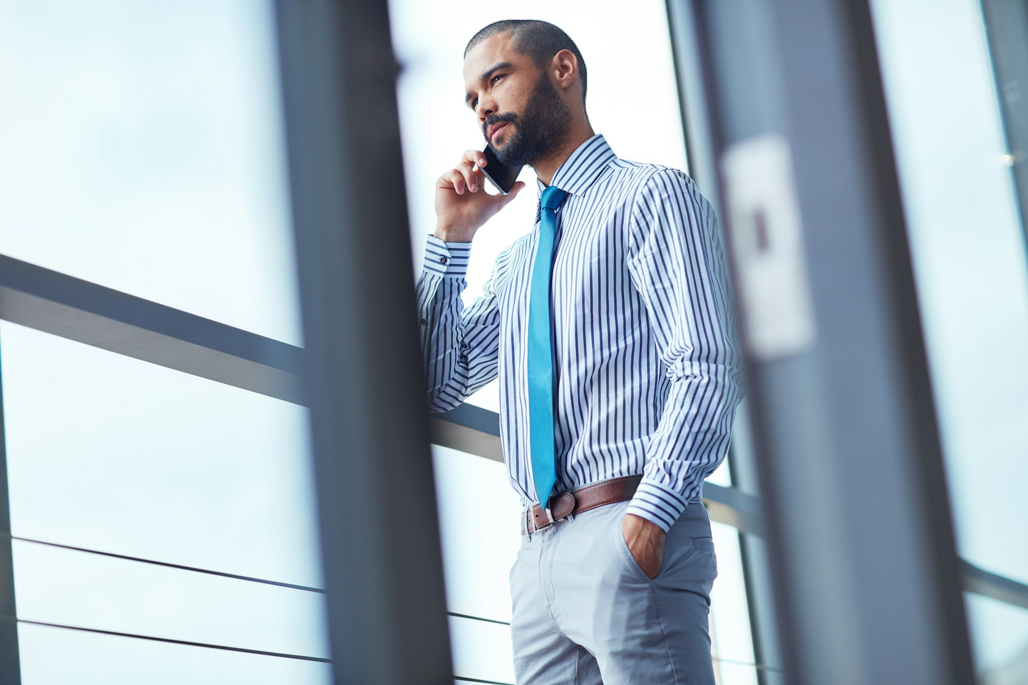 Connecting with a client. Shot of a young businessman talking on a phone at the office.